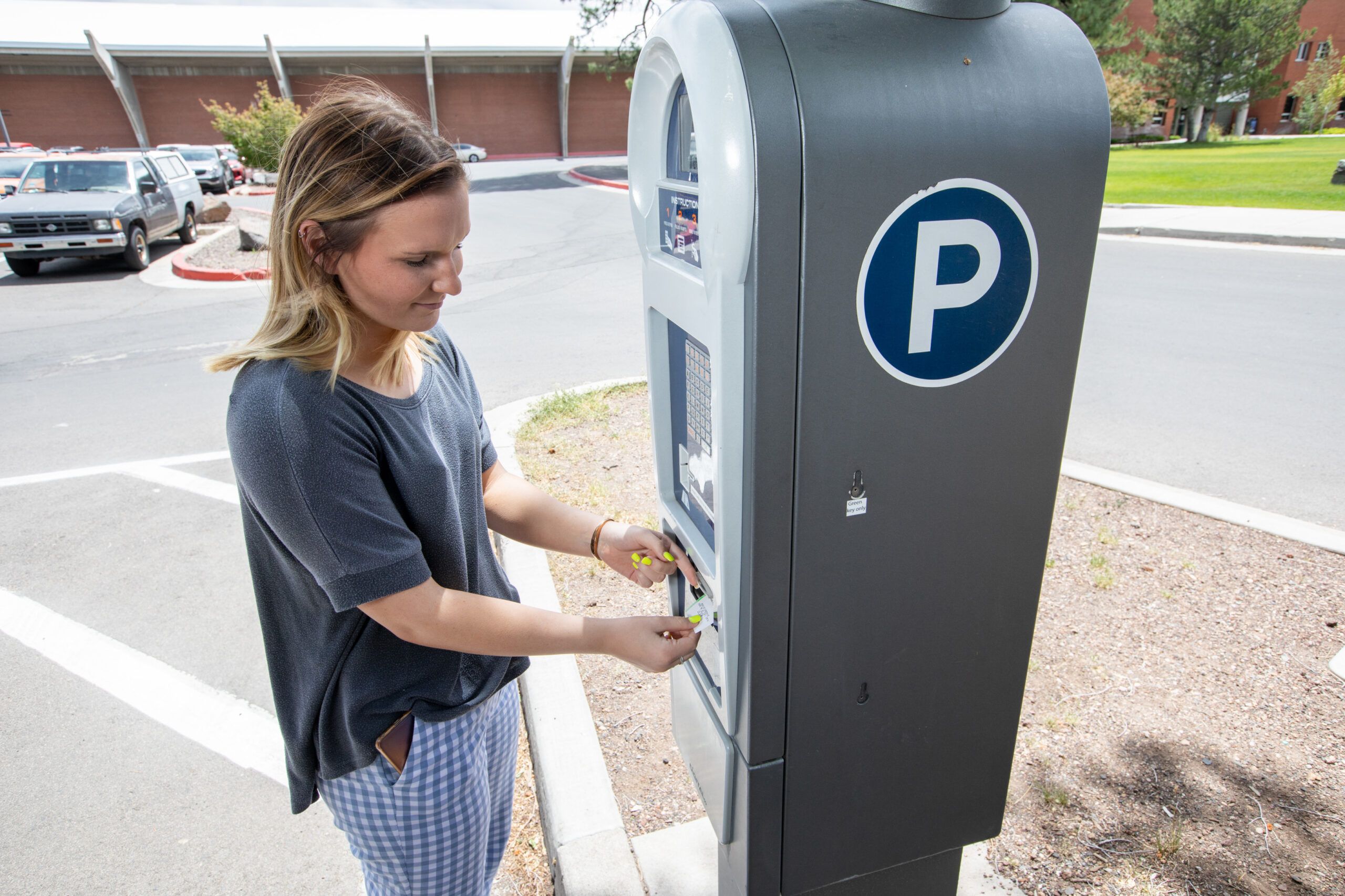 A student uses a parking kiosk on campus to purchase a parking ticket for their vehicle.