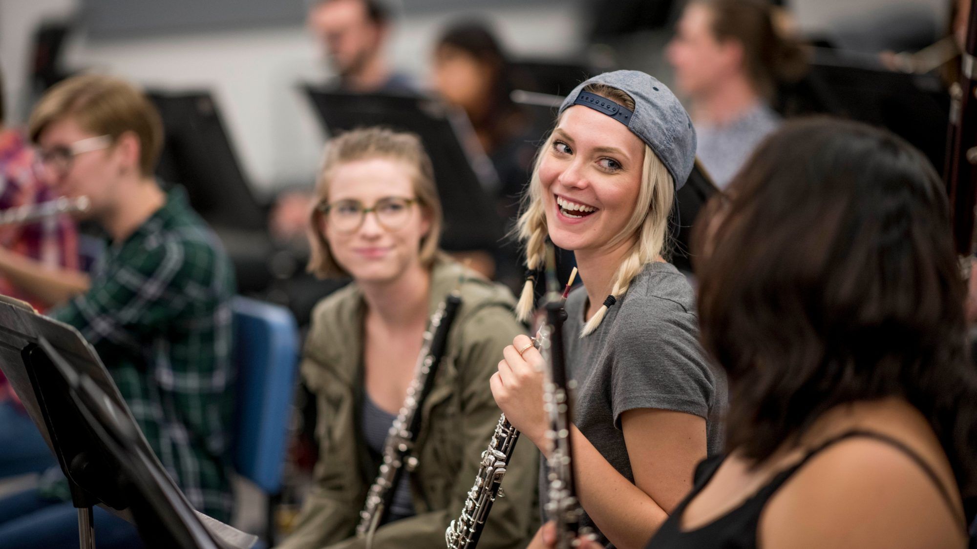 An NAU Music student smiles with friends during rehearsal.