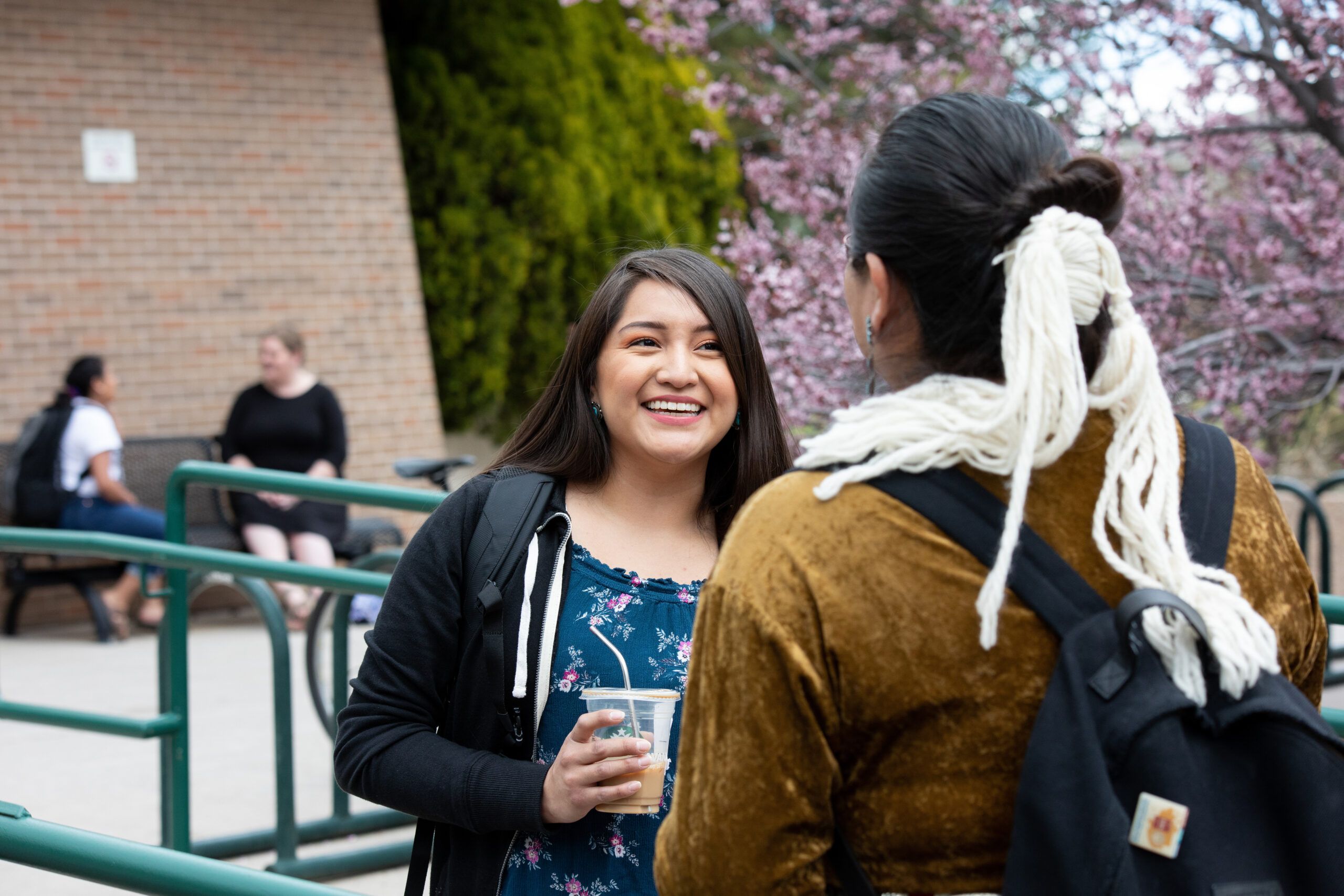 Two NAU indigenous studies students smile while chatting after class.