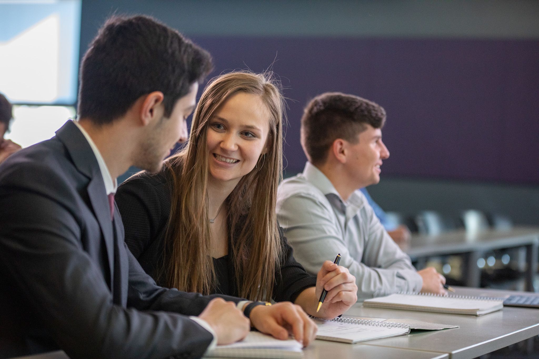 NAU Business students smile while working together in class.