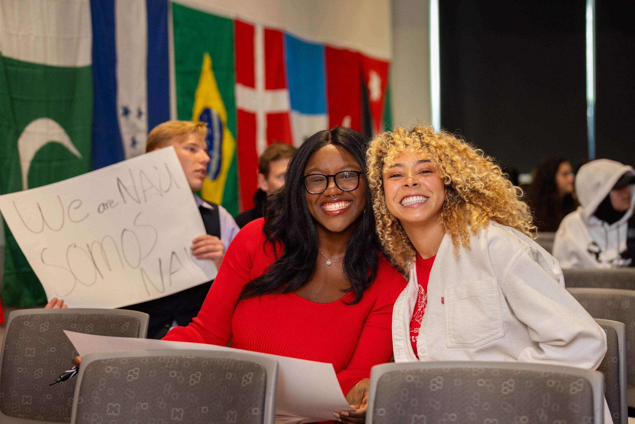 Two international students smile while attending NAU's international graduation.