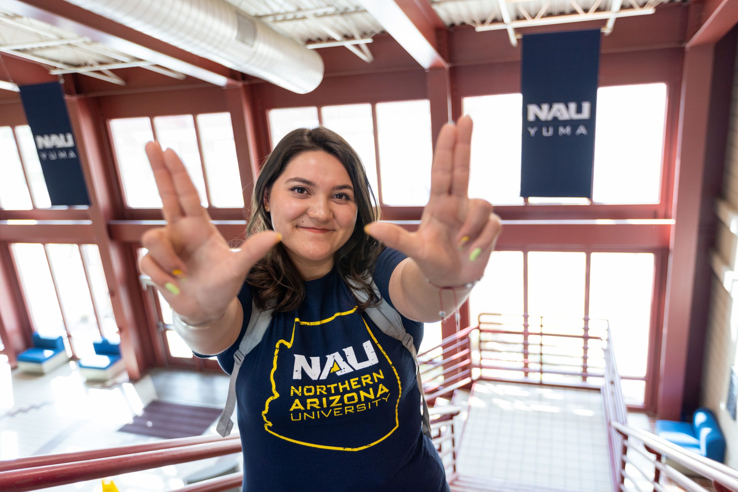 NAU-Yuma student, Katany Cardenas throws up the lumberjack L J's with her hands.
