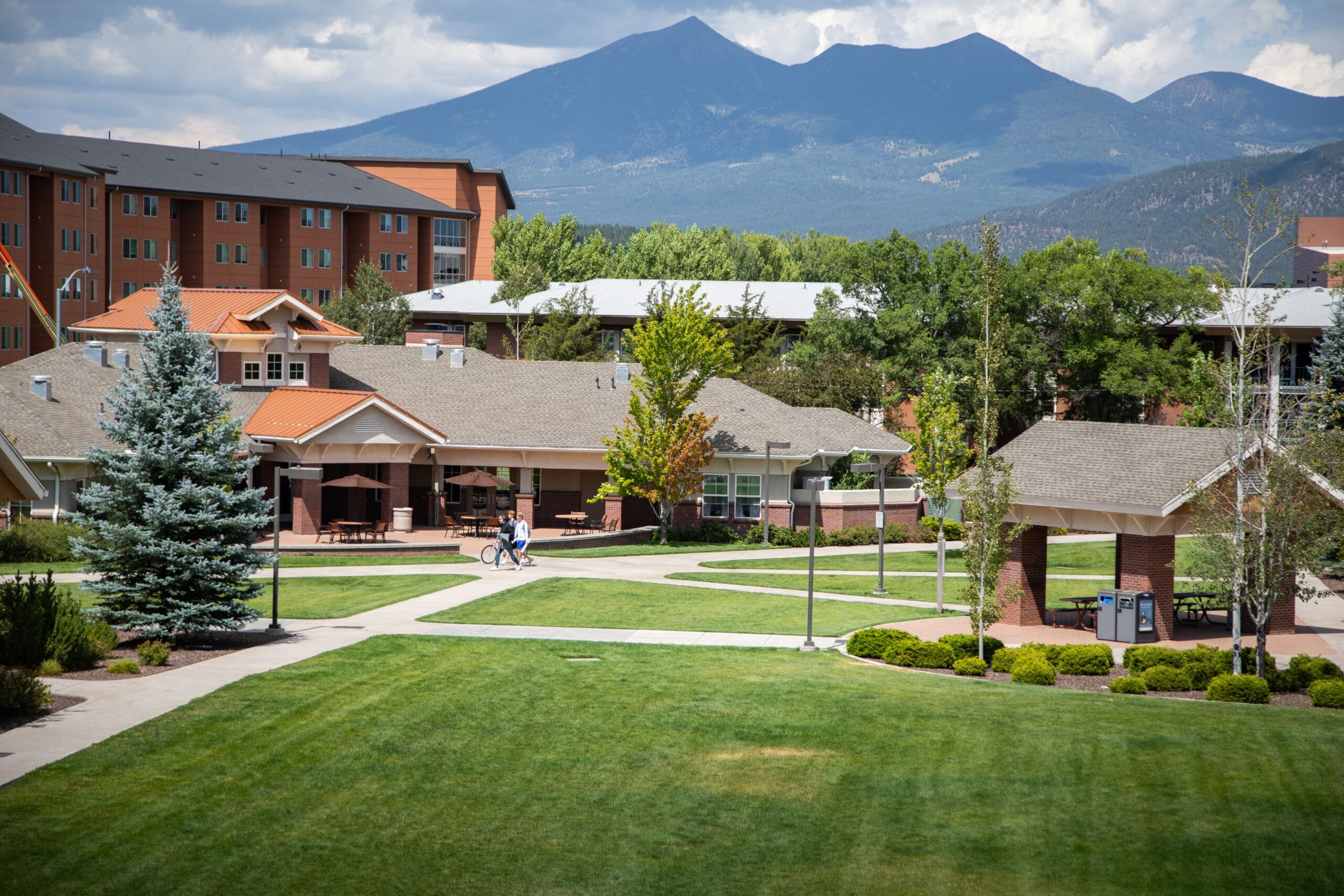 Students walking on the Flagstaff mountain campus during a sunny spring day.