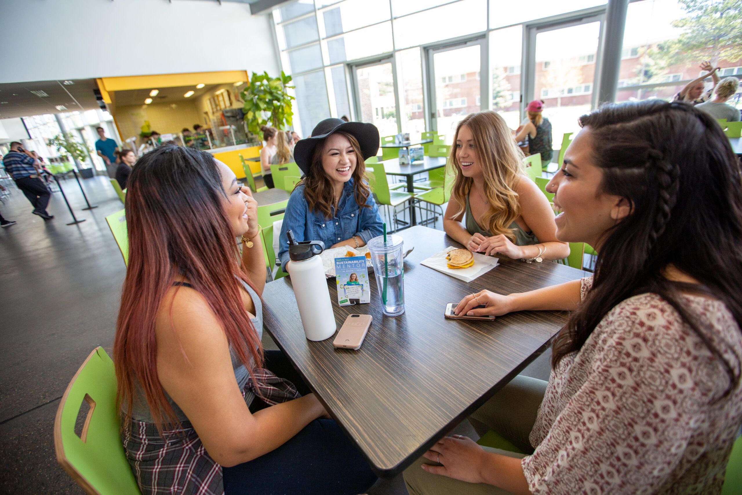 A group of student talk over food in campus dining.
