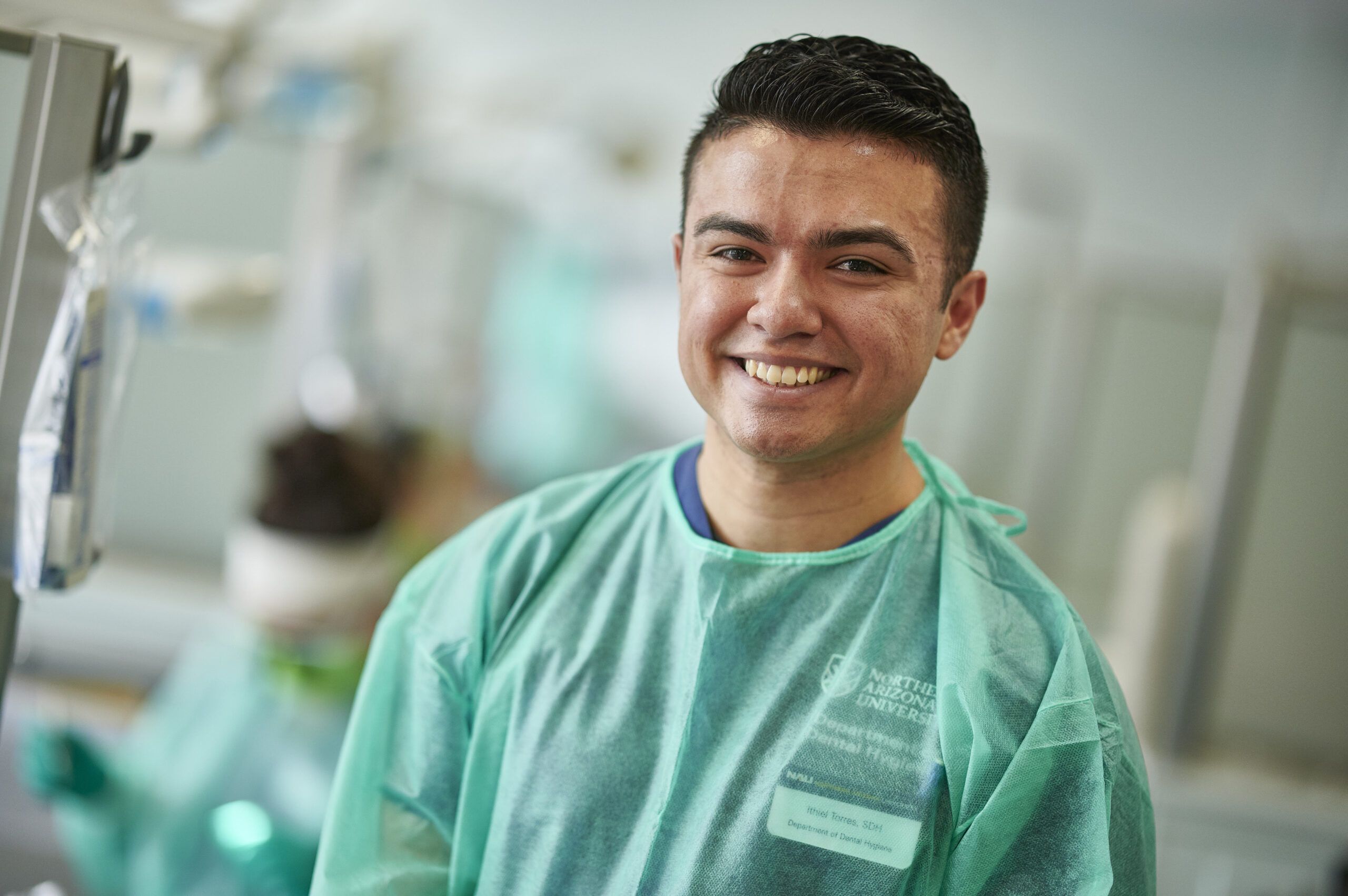 An NAU Dental Hygiene student smiles while prepping for an examination.