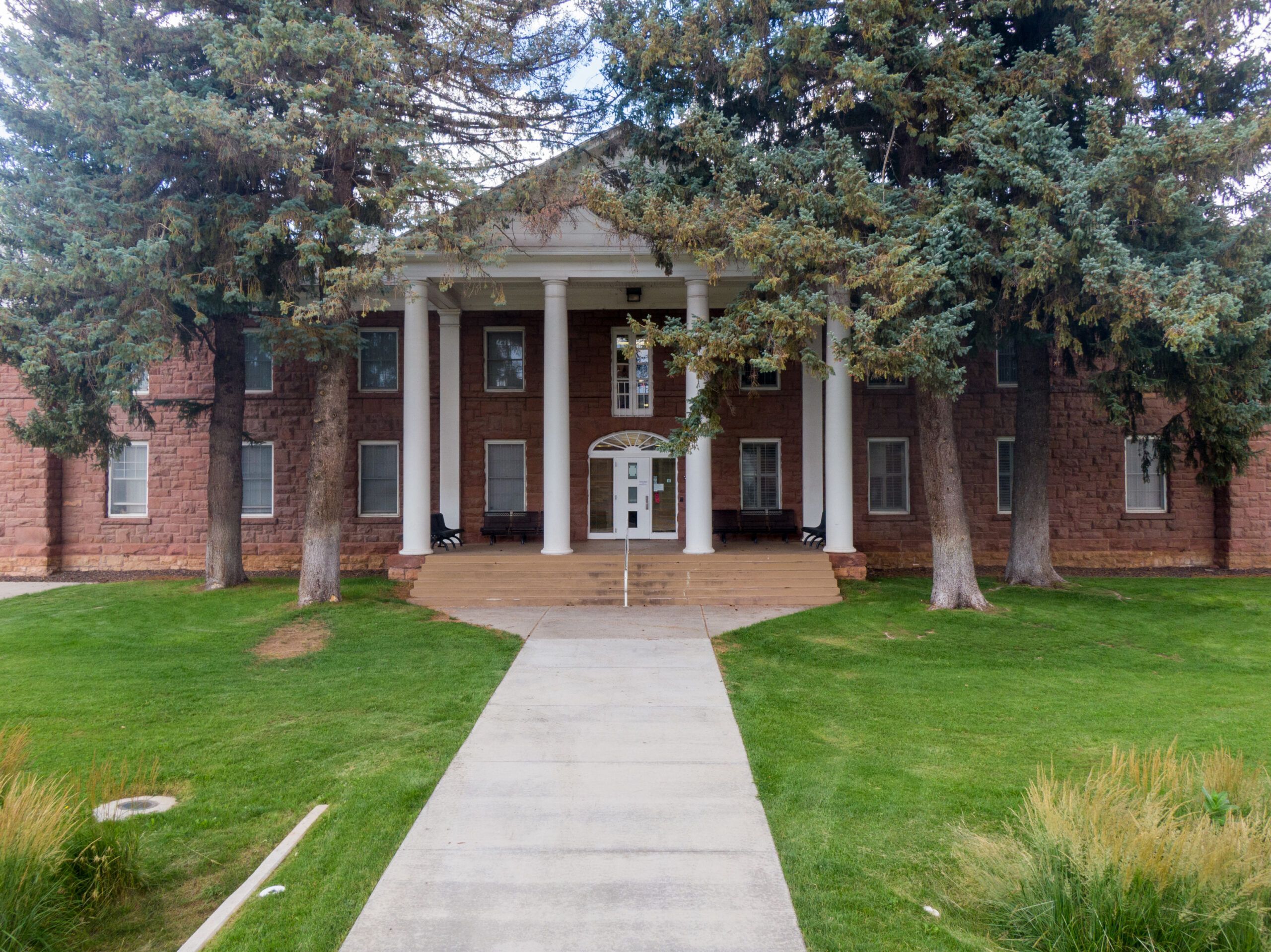 The outside of Campbell Hall, a residential hall, surrounded by large trees at Flagstaff campus.